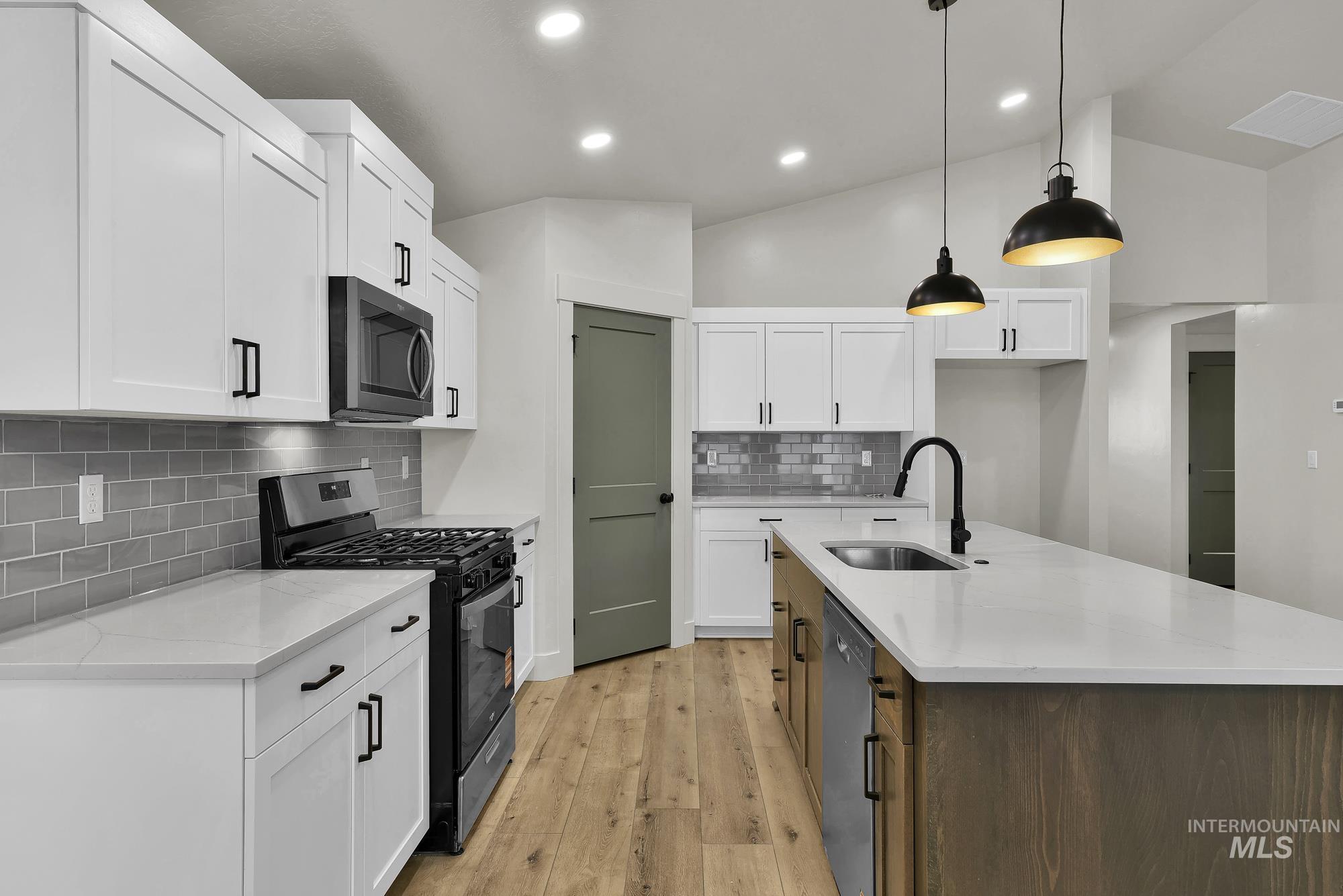 1130 Velvet Loop Wilder, ID 83676 - Photo 12 of 35 Modern kitchen featuring a large central island with a sink and pendant lighting