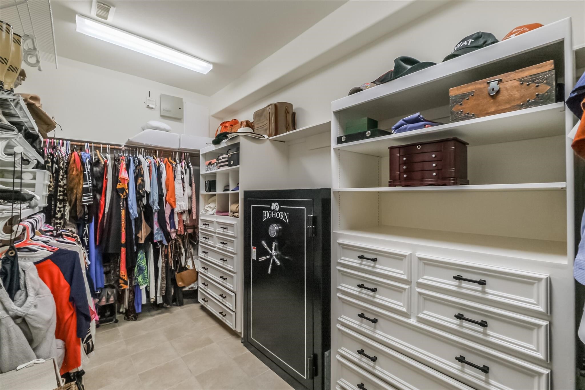 11413 Gallant Ridge Lane Houston, TX 77082 - Photo 37 of 50 Spacious walk-in closet featuring ample hanging space, built-in drawers, and shelving for clothing and accessories. Bright lighting and a well-organized layout provide excellent functionality and storage. A secure safe is included with the sale. All other personal property shown is not included in the sale.
