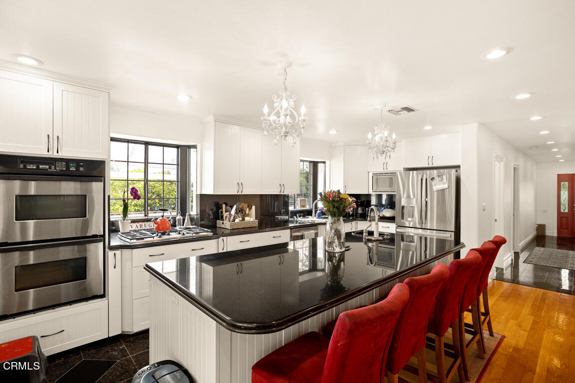 4900 Crown Avenue La Canada Flintridge, CA 91011 - Photo 13 of 41 a kitchen with stainless steel appliances granite countertop a sink dishwasher a dining table and chairs with wooden floor