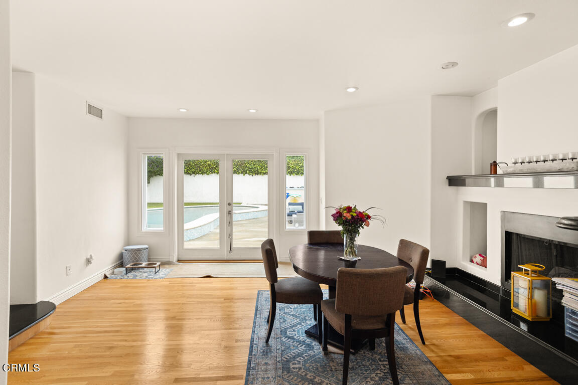 4900 Crown Avenue La Canada Flintridge, CA 91011 - Photo 17 of 41 a dining room with furniture a fireplace and wooden floor