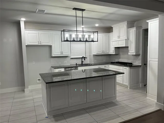 a kitchen with a sink stove and cabinets