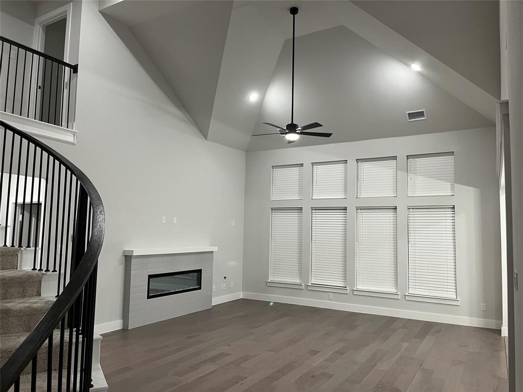 2409 Park Oaks Drive Midlothian, TX 76065 - Photo 10 of 18 an empty room with wooden floor fan and windows