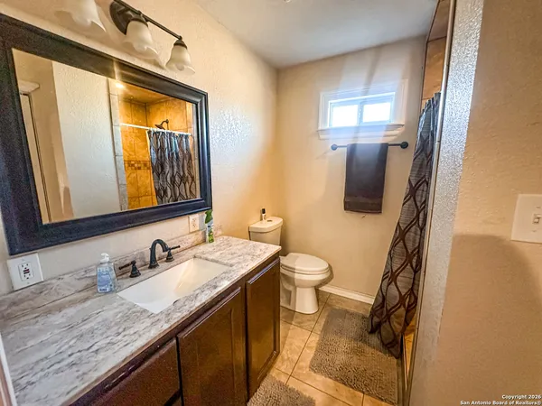 a bathroom with a granite countertop sink and a mirror