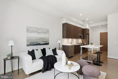 a living room with furniture potted plant and kitchen area
