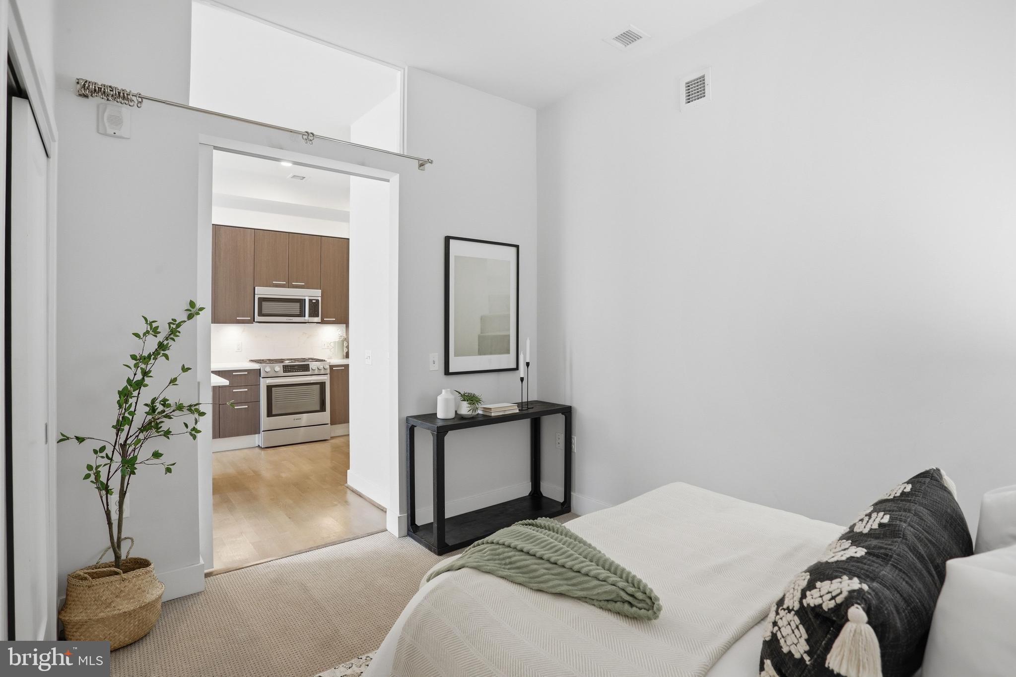 525 Water Street Southwest, Unit 311 Washington, DC 20024 - Photo 21 of 53 a bedroom with a bed and a potted plant