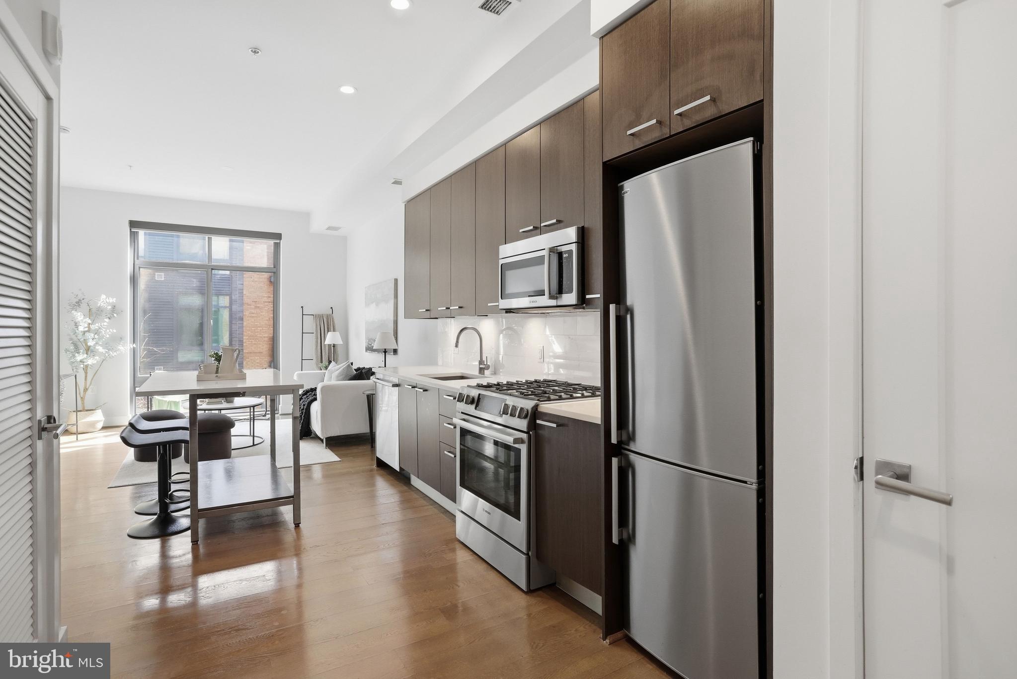 525 Water Street Southwest, Unit 311 Washington, DC 20024 - Photo 7 of 53 a kitchen with stainless steel appliances a refrigerator stove microwave and sink