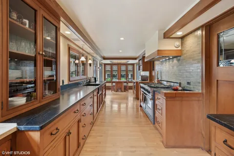 a large kitchen with stainless steel appliances kitchen island granite countertop a large counter top and a stove