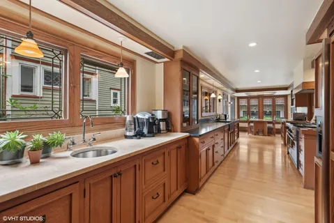 a view of a dining room with furniture large windows and a chandelier