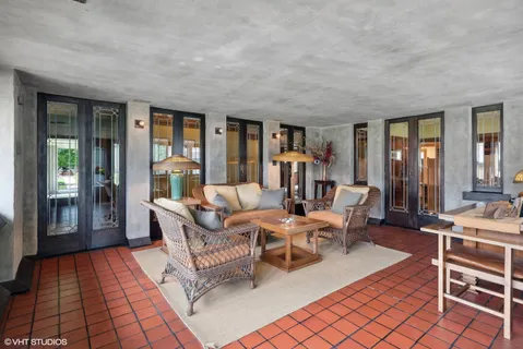 a living room with furniture a lamp and large window