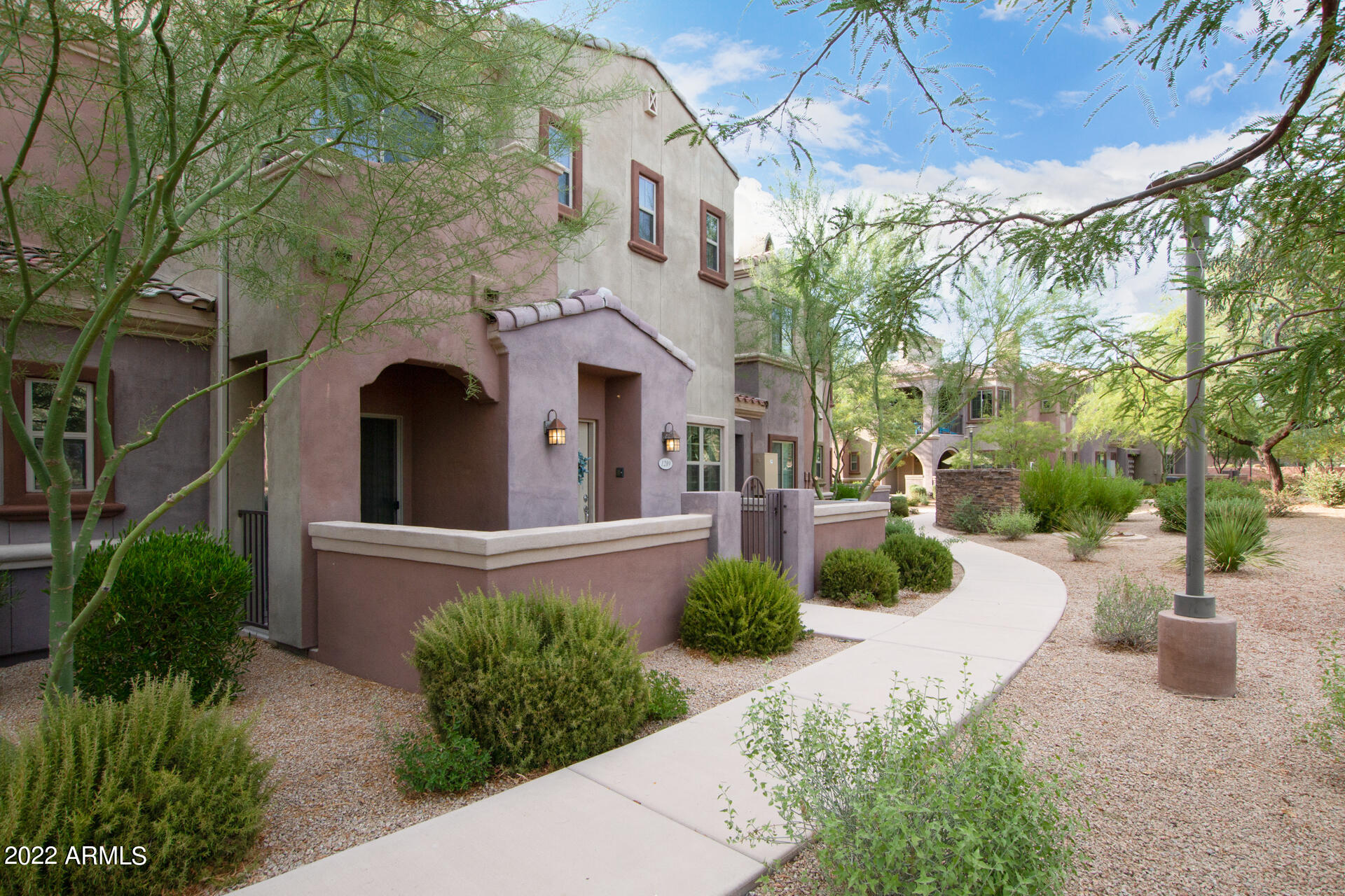 3935 East Rough Rider Road, Unit 1289 Phoenix, AZ 85050 - Photo 23 of 60 a front view of a house with garden