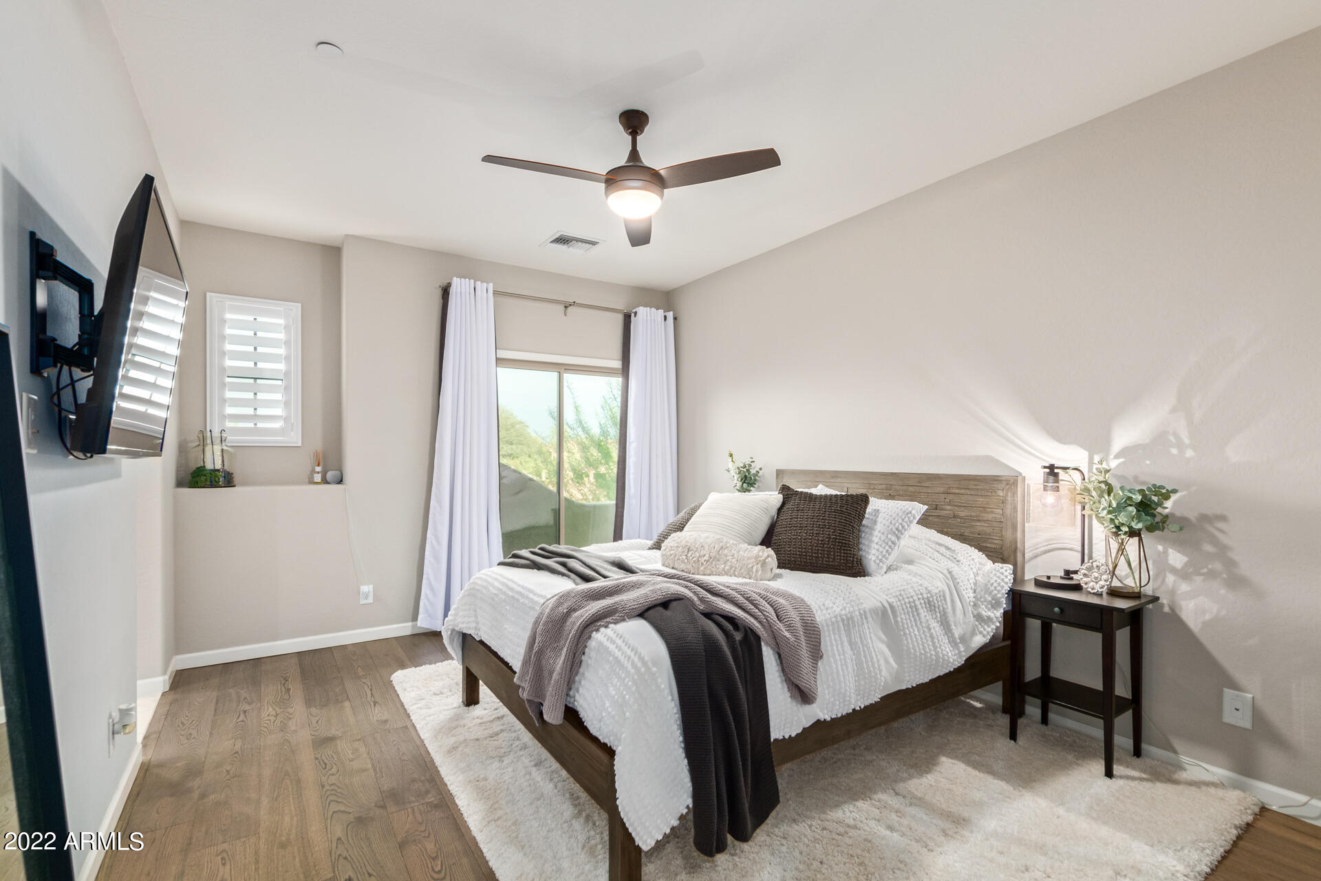 3935 East Rough Rider Road, Unit 1289 Phoenix, AZ 85050 - Photo 10 of 60 a bedroom with a large bed and a chandelier