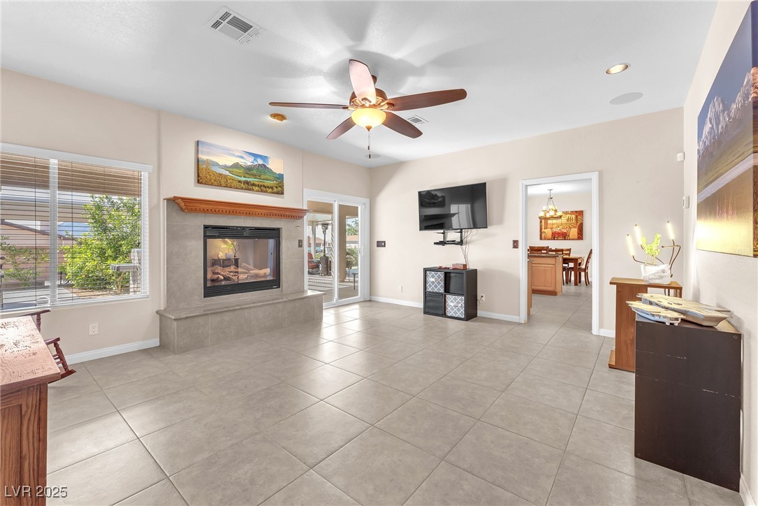 2251 Thoroughbred Road Henderson, NV 89002 - Photo 15 of 60 Living room featuring a tiled fireplace, visible vents, a ceiling fan, and light tile patterned flooring