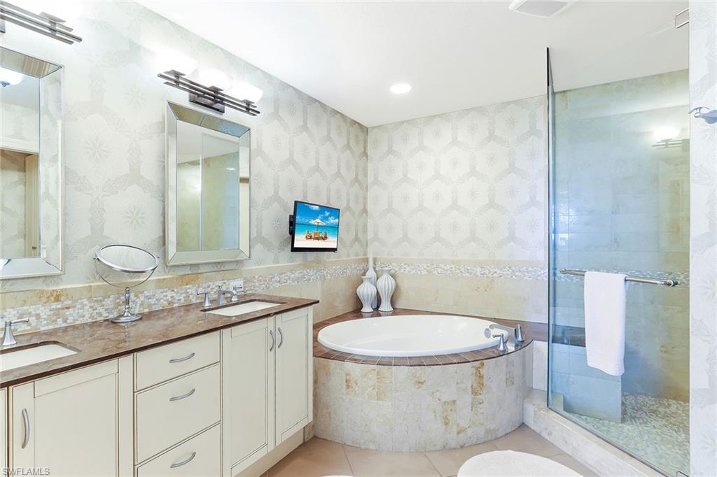 9115 Strada Place, Unit 5414 Naples, FL 34108 - Photo 12 of 26 a bathroom with a granite countertop sink toilet and shower