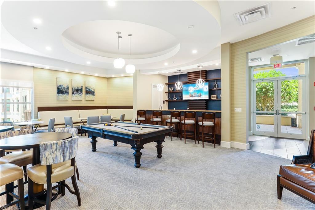 9115 Strada Place, Unit 5414 Naples, FL 34108 - Photo 25 of 26 a living room with furniture a flat screen tv and a large window
