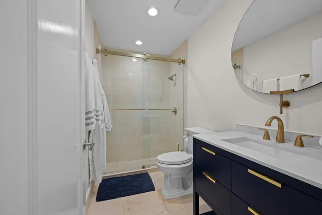 a bedroom with a bed a chandelier and a painting on the wall