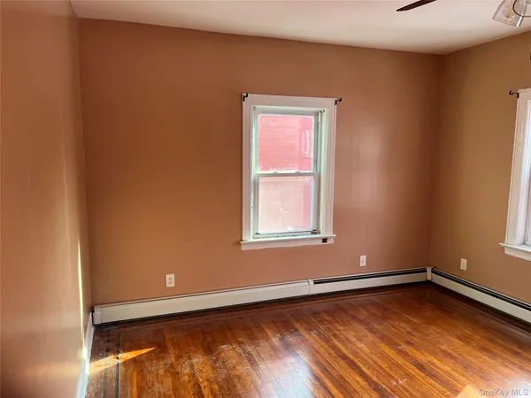a view of a room with wooden floor and window