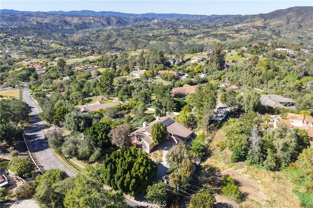2248 Mil Sorpresas Drive Fallbrook, CA 92028 - Photo 20 of 74 an aerial view of a house with a yard and mountain view in back