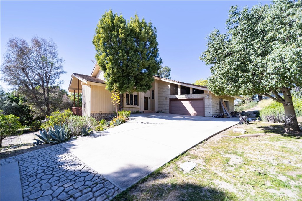 2248 Mil Sorpresas Drive Fallbrook, CA 92028 - Photo 4 of 74 a front view of a house with a yard and garage