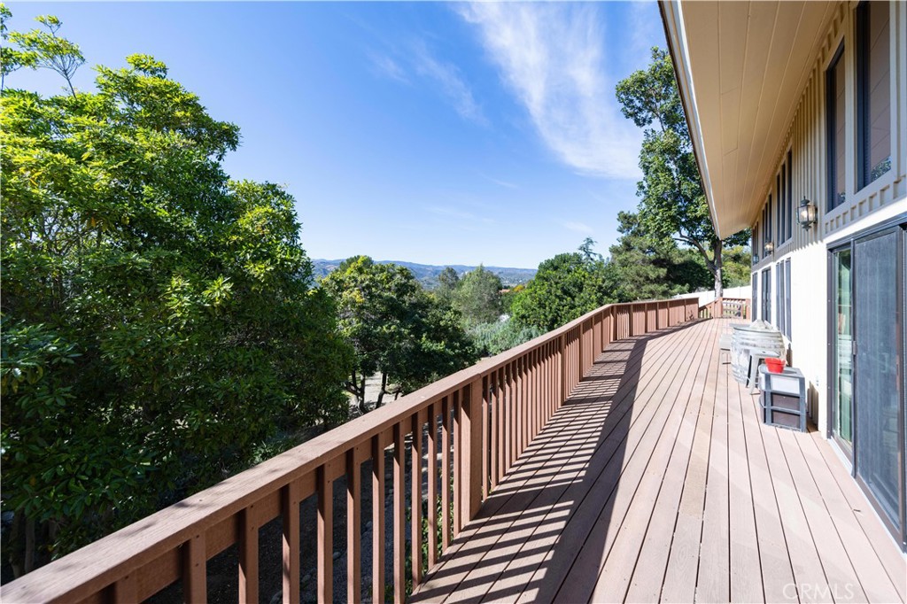 2248 Mil Sorpresas Drive Fallbrook, CA 92028 - Photo 66 of 74 a balcony with wooden floor and trees in the back