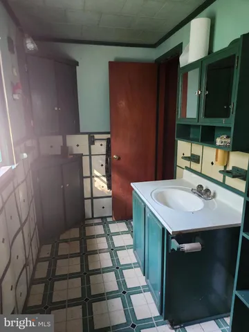 a kitchen with a sink a refrigerator and cabinets