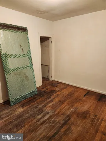 an empty room with wooden floor and a window