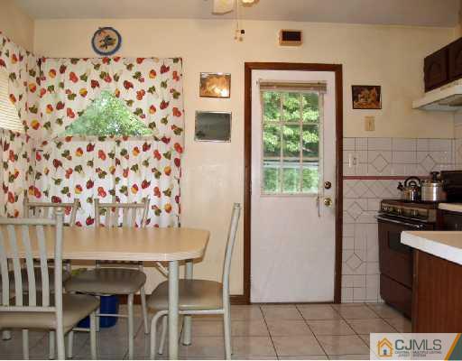 18 Brookville Road Edison, NJ 08817 - Photo 3 of 8 a kitchen with granite countertop a refrigerator and a stove top oven