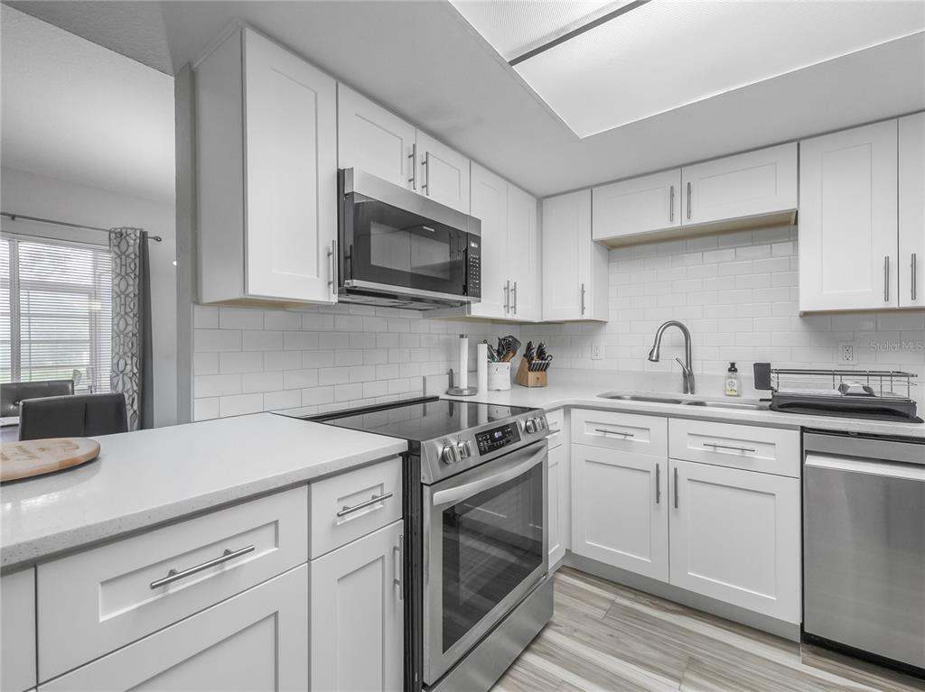 622 Fairways Circle, Unit A Ocala, FL 34472 - Photo 5 of 26 a kitchen with cabinets stainless steel appliances a sink and a microwave