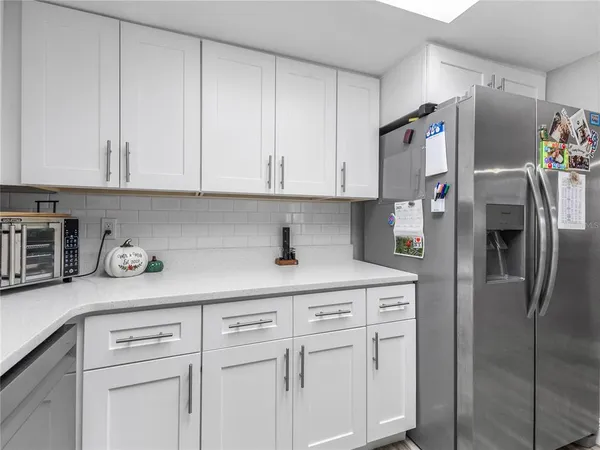 a kitchen with stainless steel appliances white cabinets and a refrigerator