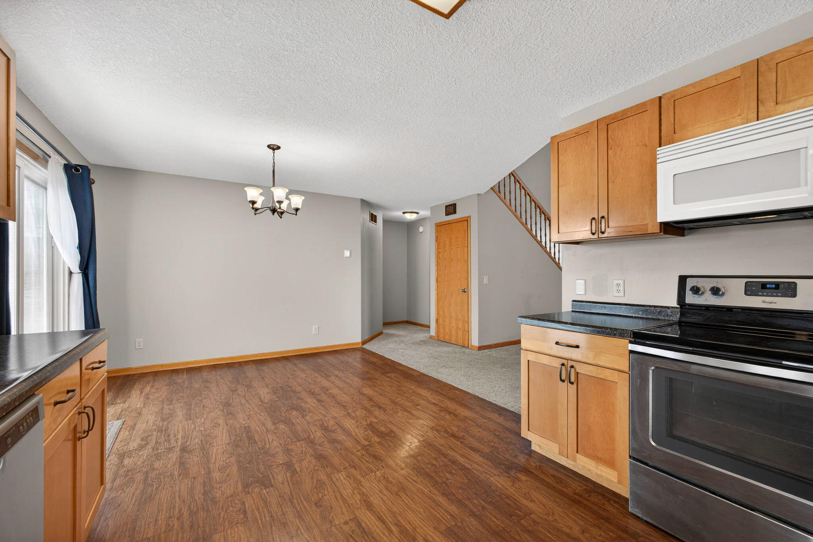 313 Sullivan Drive Colona, IL 61241 - Photo 12 of 41 a view of an empty room with a kitchen and wooden floor