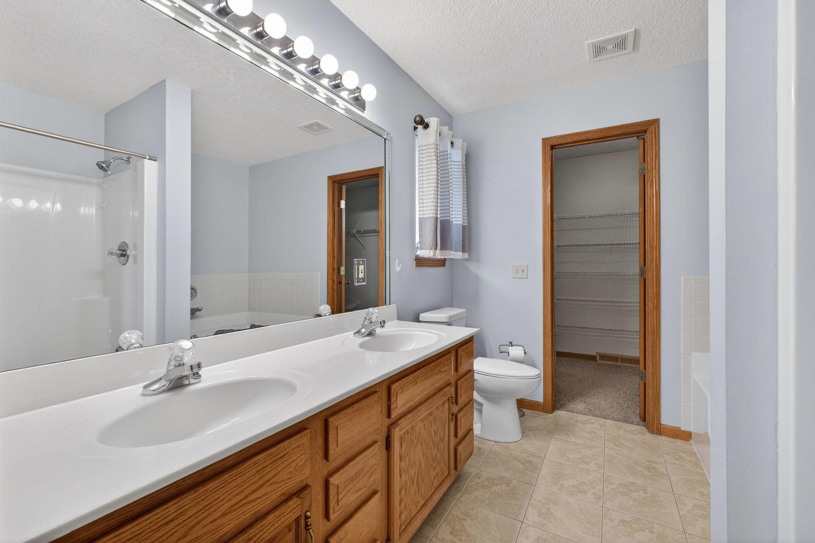 313 Sullivan Drive Colona, IL 61241 - Photo 19 of 41 a spacious bathroom with a double vanity sink a large mirror and a shower
