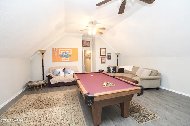 a room with pool table and wooden floor