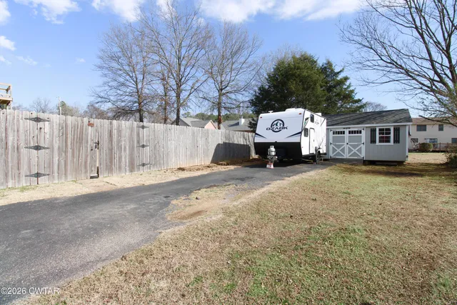 a front view of a house with a yard and parking space