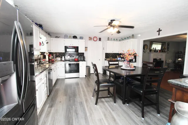 a kitchen with stainless steel appliances wooden floor and dining table