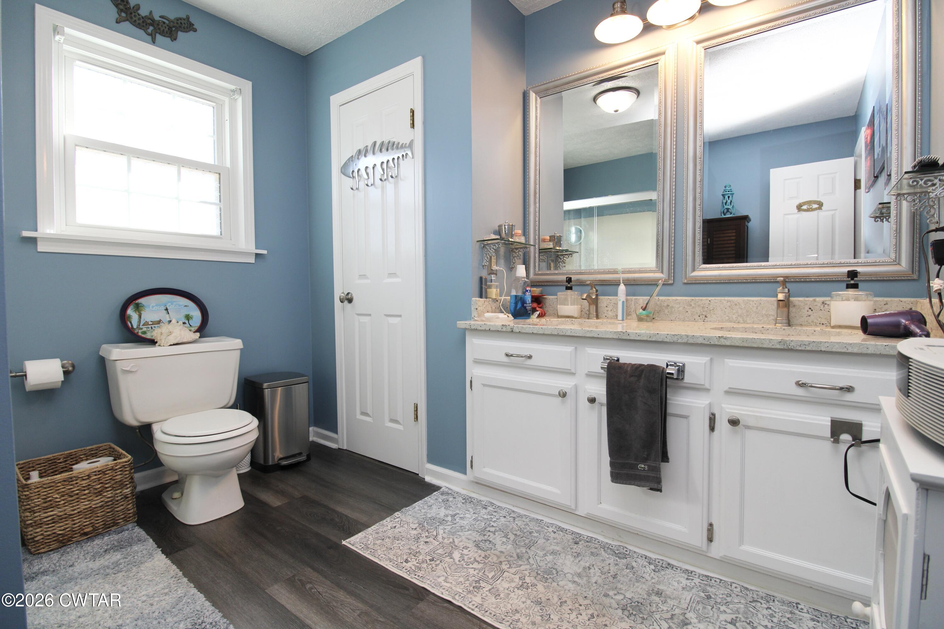 285 Meadowbrook Circle Lexington, TN 38351 - Photo 10 of 26 a bathroom with a sink toilet a mirror and vanity
