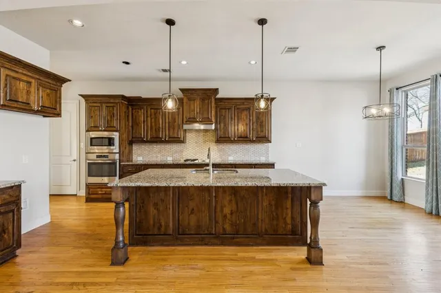 a kitchen with kitchen island a counter top space appliances and cabinets