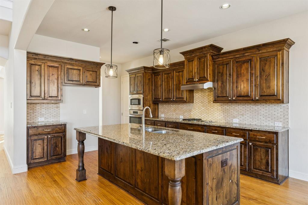 10234 Cava Road Frisco, TX 75035 - Photo 12 of 40 a kitchen with stainless steel appliances granite countertop a sink a stove and a wooden floors