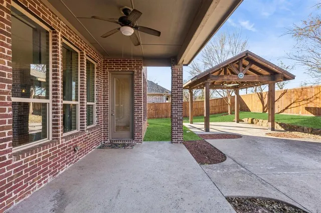 a view of a house with porch and wooden fence