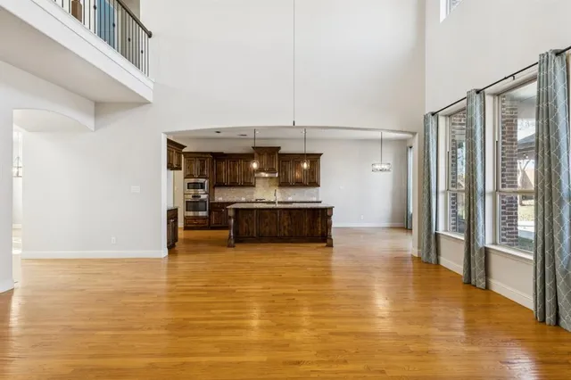 a view of a kitchen with stainless steel appliances wooden floor and chair