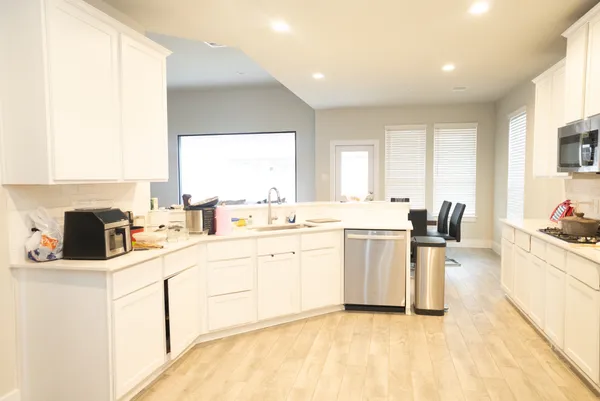 a kitchen with a refrigerator and a stove top oven