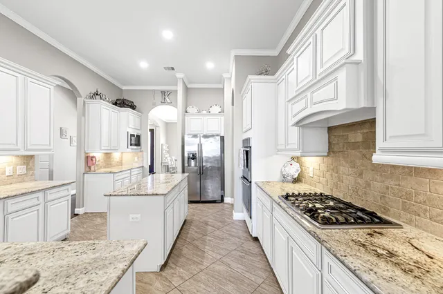 a kitchen with stainless steel appliances a dining table and chairs