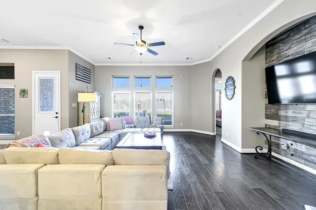 a bedroom with a large bed a flat tv screen and a chandelier