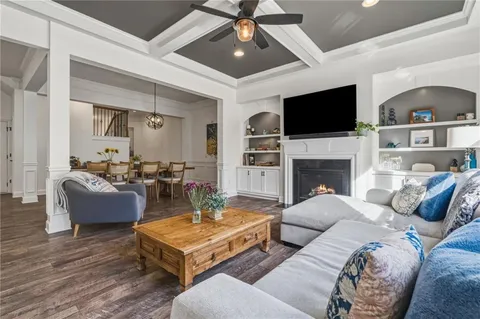 a kitchen with stainless steel appliances granite countertop a refrigerator a stove a sink a dining table and chairs with wooden floor
