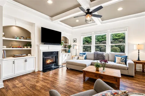a kitchen with stainless steel appliances kitchen island granite countertop a refrigerator a stove a microwave oven a sink with island chairs and wooden floor