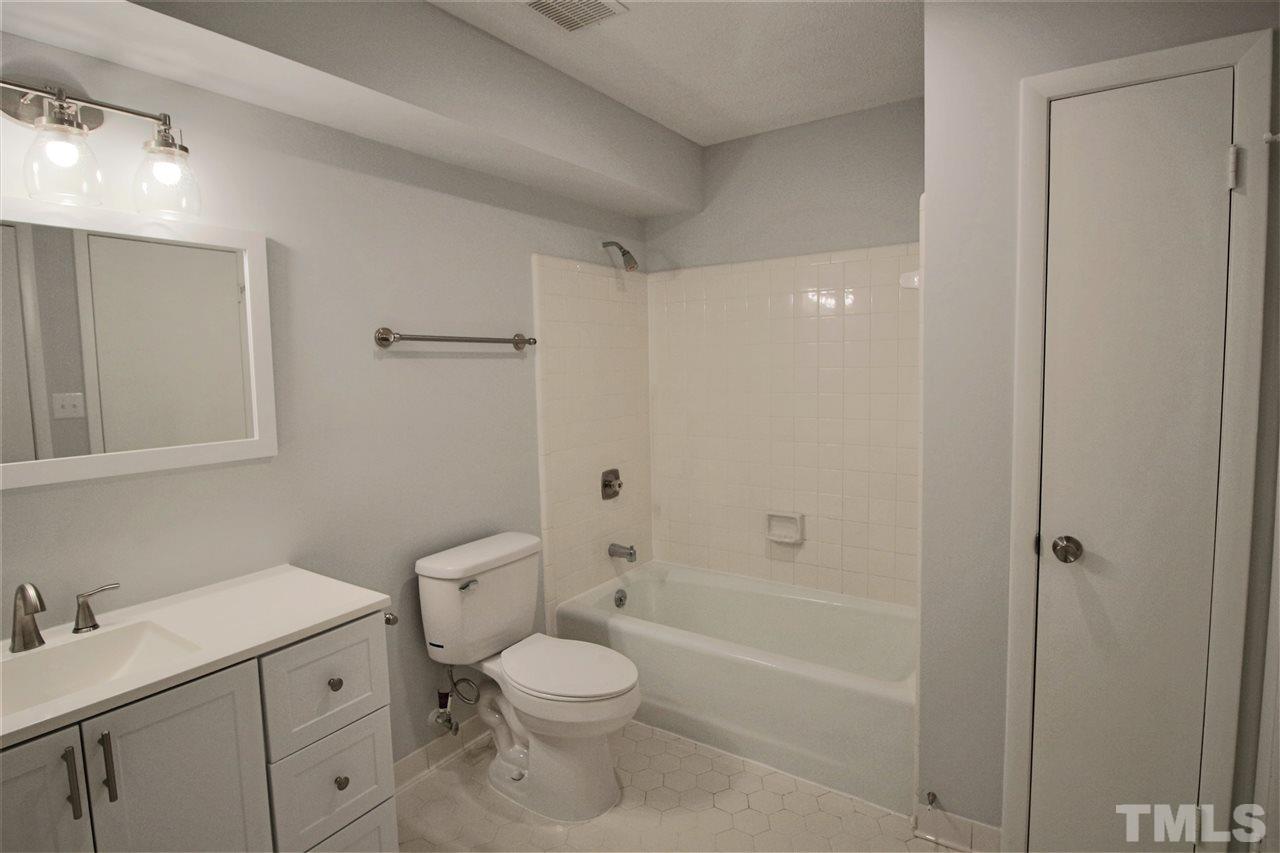 5815 Shady Grove Circle Raleigh, NC 27609 - Photo 15 of 19 a bathroom with a granite countertop toilet a sink and a bathtub