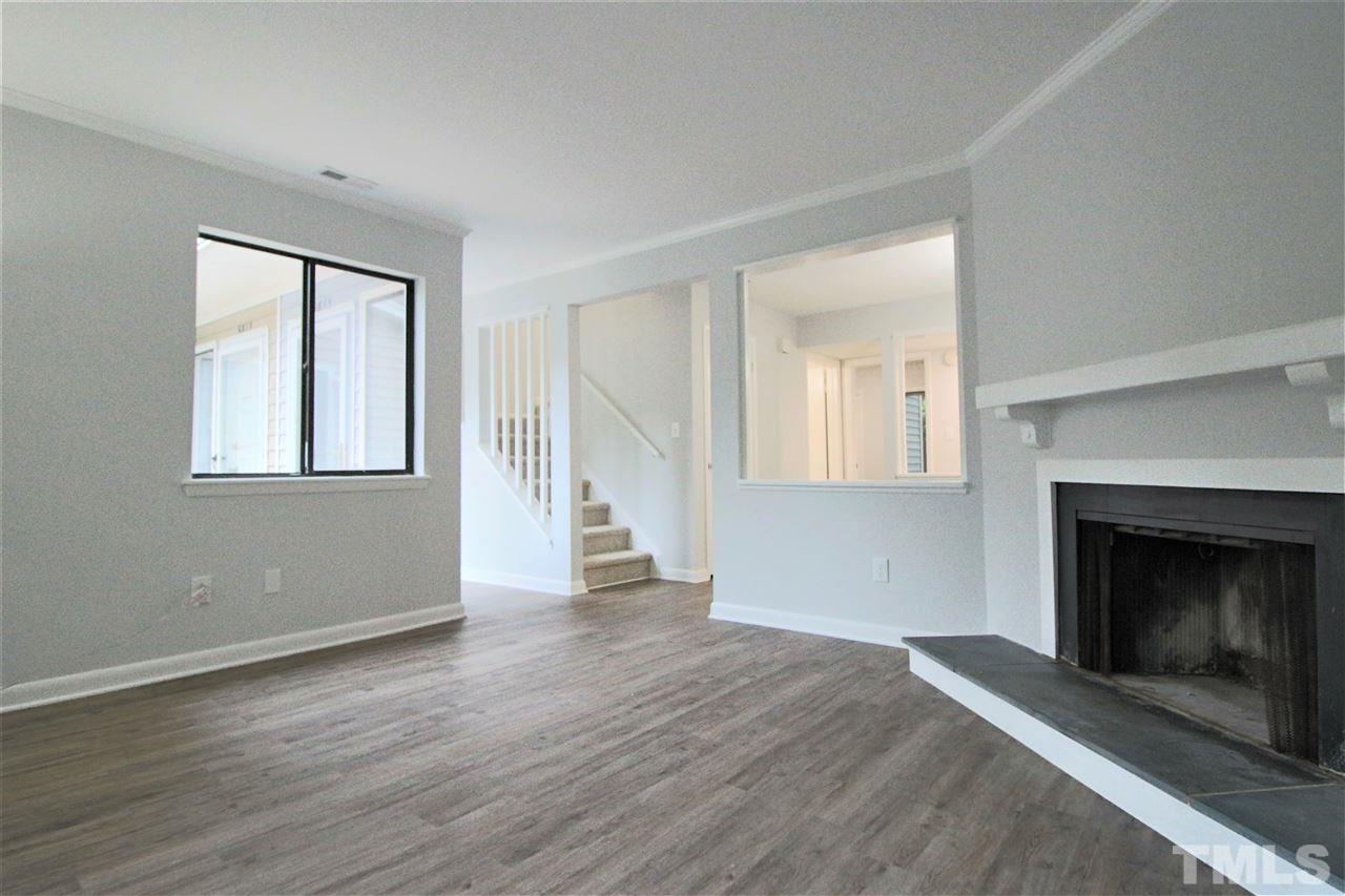 5815 Shady Grove Circle Raleigh, NC 27609 - Photo 3 of 19 an empty room with wooden floor fireplace and windows