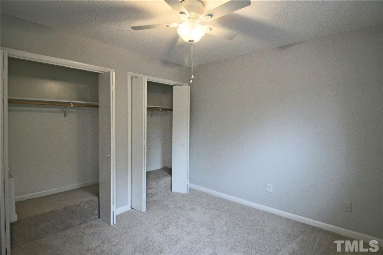 5815 Shady Grove Circle Raleigh, NC 27609 - Photo 10 of 19 an empty room with a chandelier fan and a bathroom