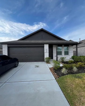 a front view of house with yard and trees around