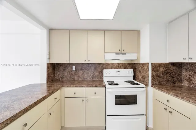 a kitchen with granite countertop white cabinets and white appliances