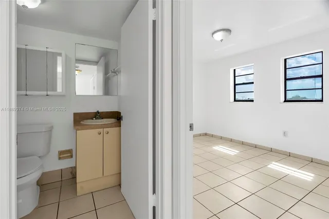 a bathroom with a toilet a sink a mirror and shower