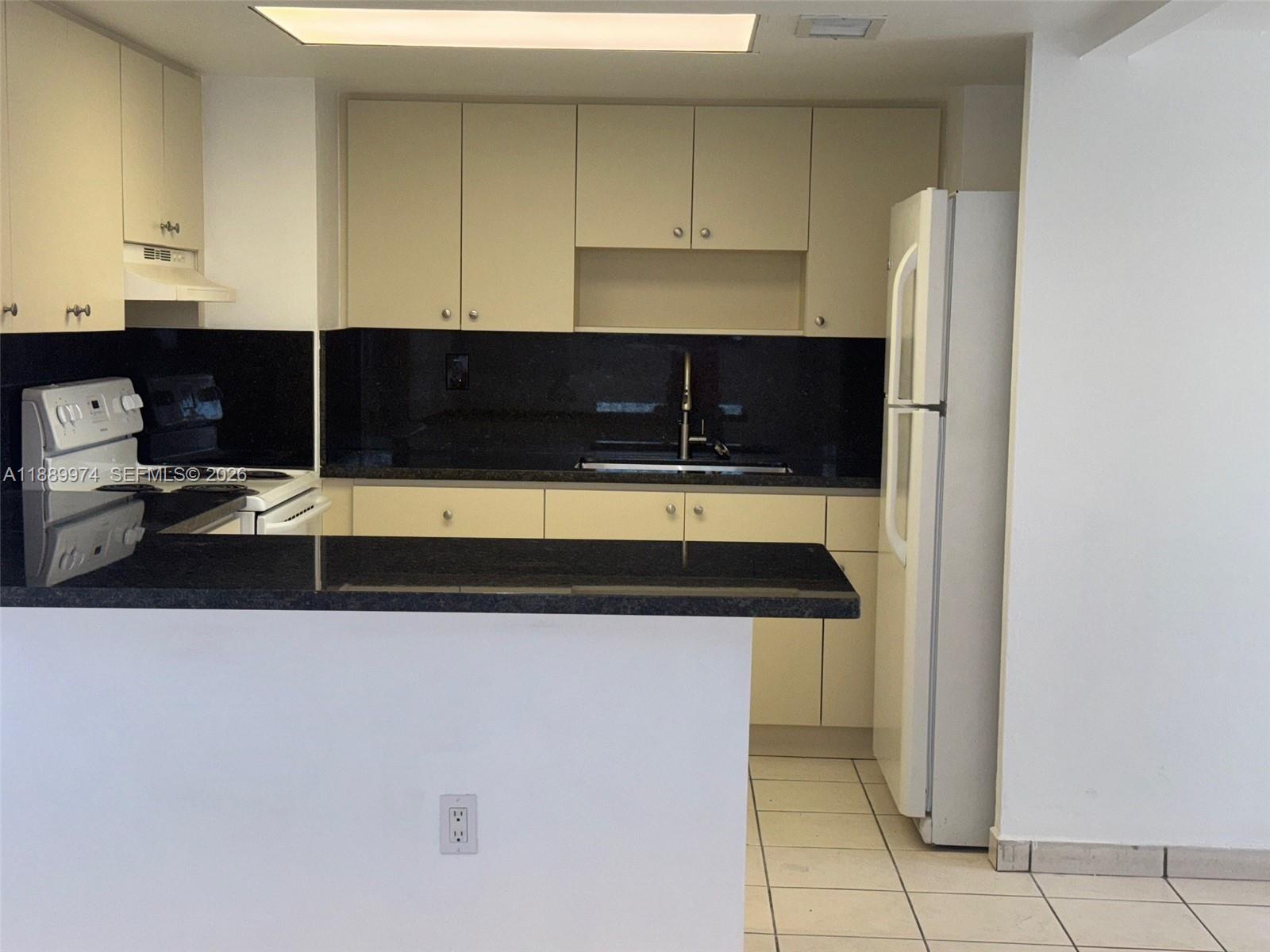 3945 Southwest 89th Avenue, Unit 201 Miami, FL 33165 - Photo 15 of 24 a kitchen with a sink and a refrigerator